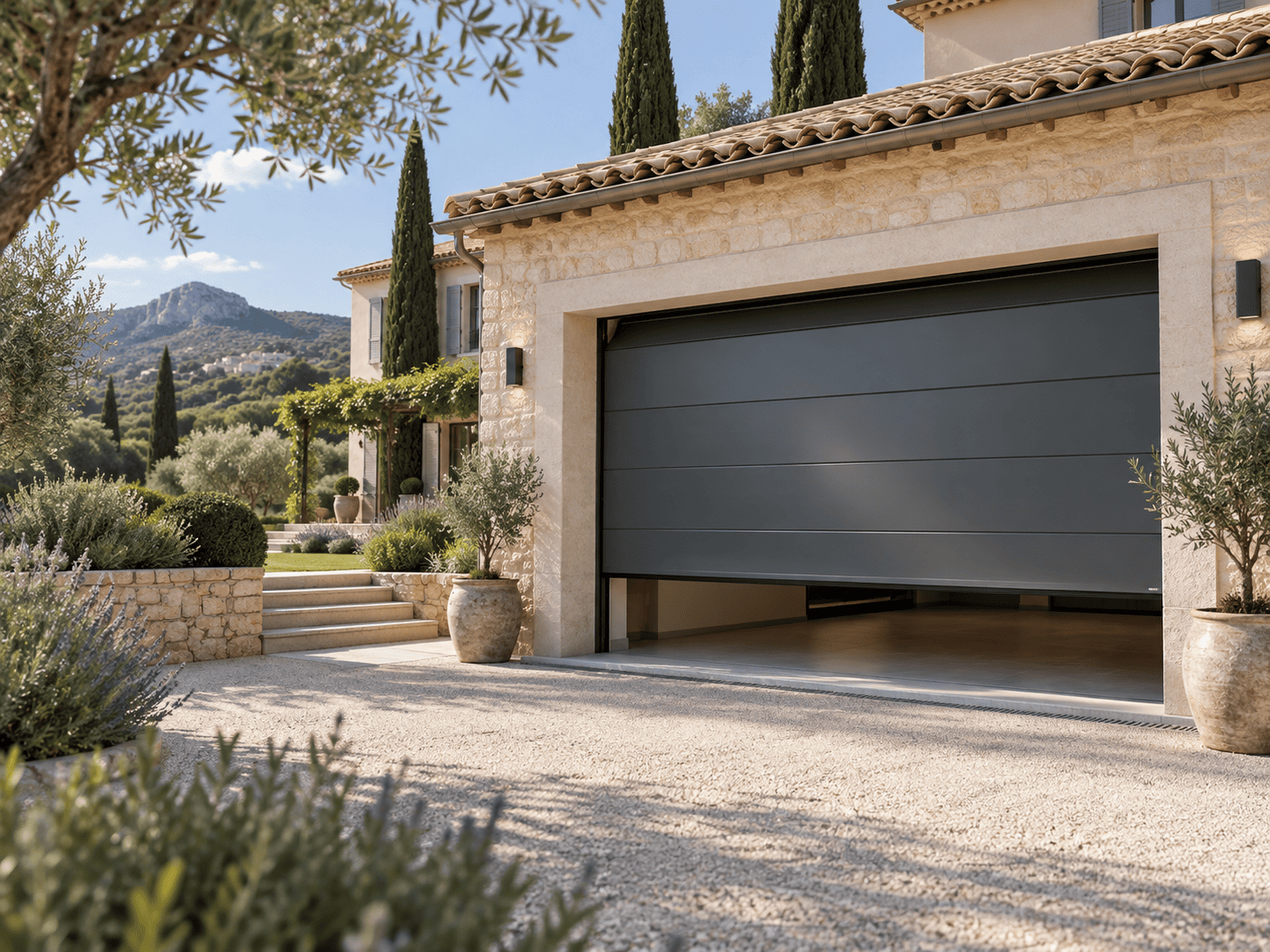 Porte de garage sectionnelle anthracite sur une maison en pierre en Provence